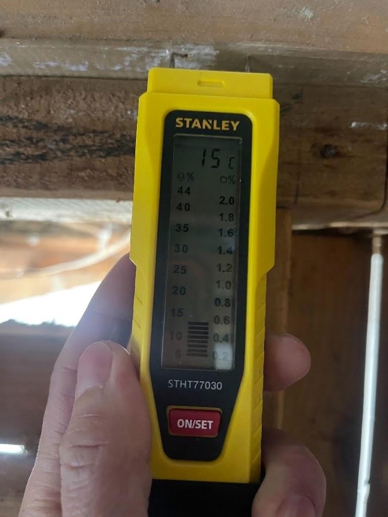 Moisture meter checking timber after a ceiling pipe leak