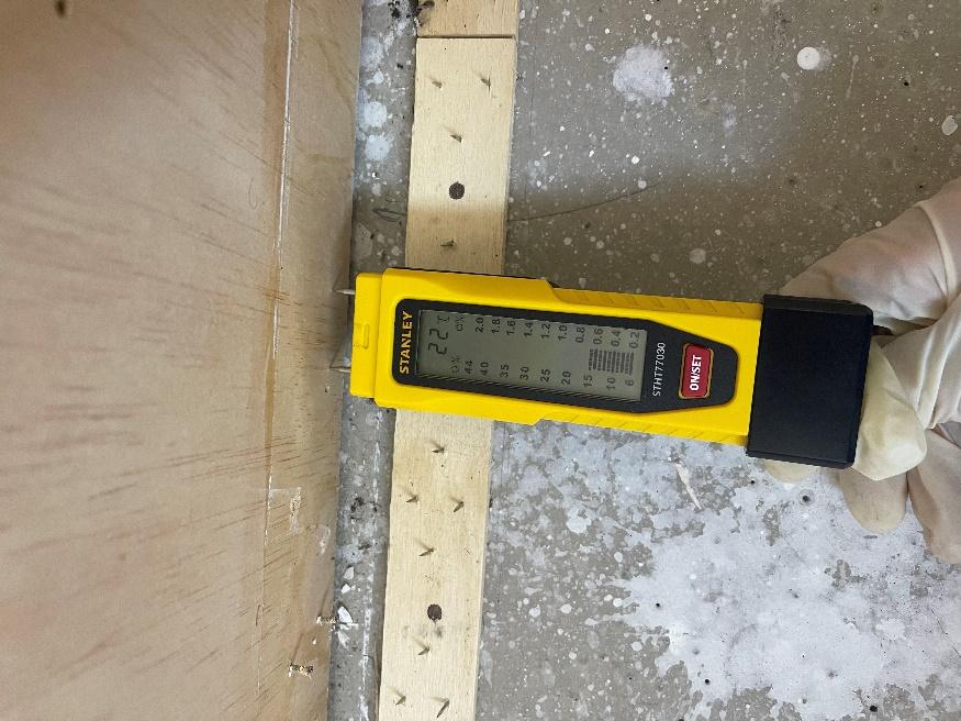 Initial floor moisture reading during structural drying assessment