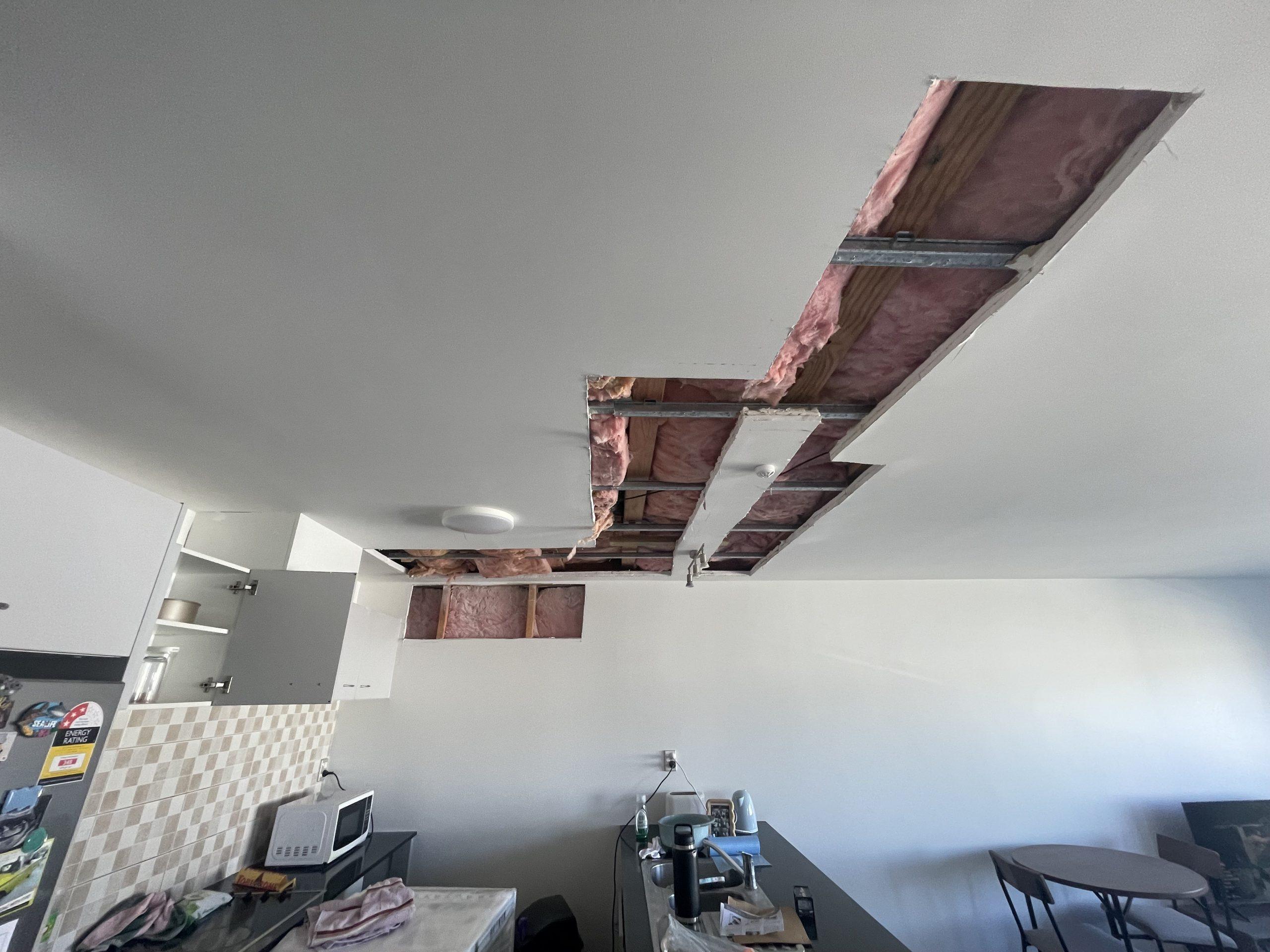 Opened ceiling cavity showing exposed framing and insulation after the Onehunga pipe leak