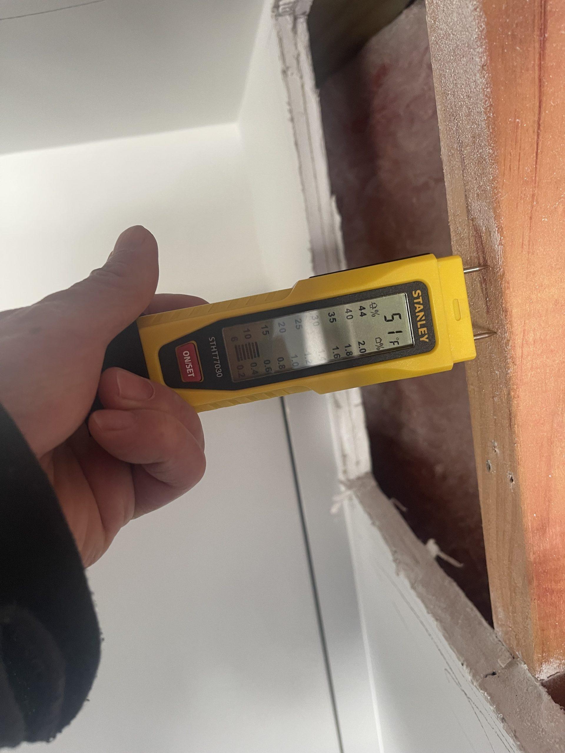 Moisture meter checking exposed timber framing following a ceiling water leak