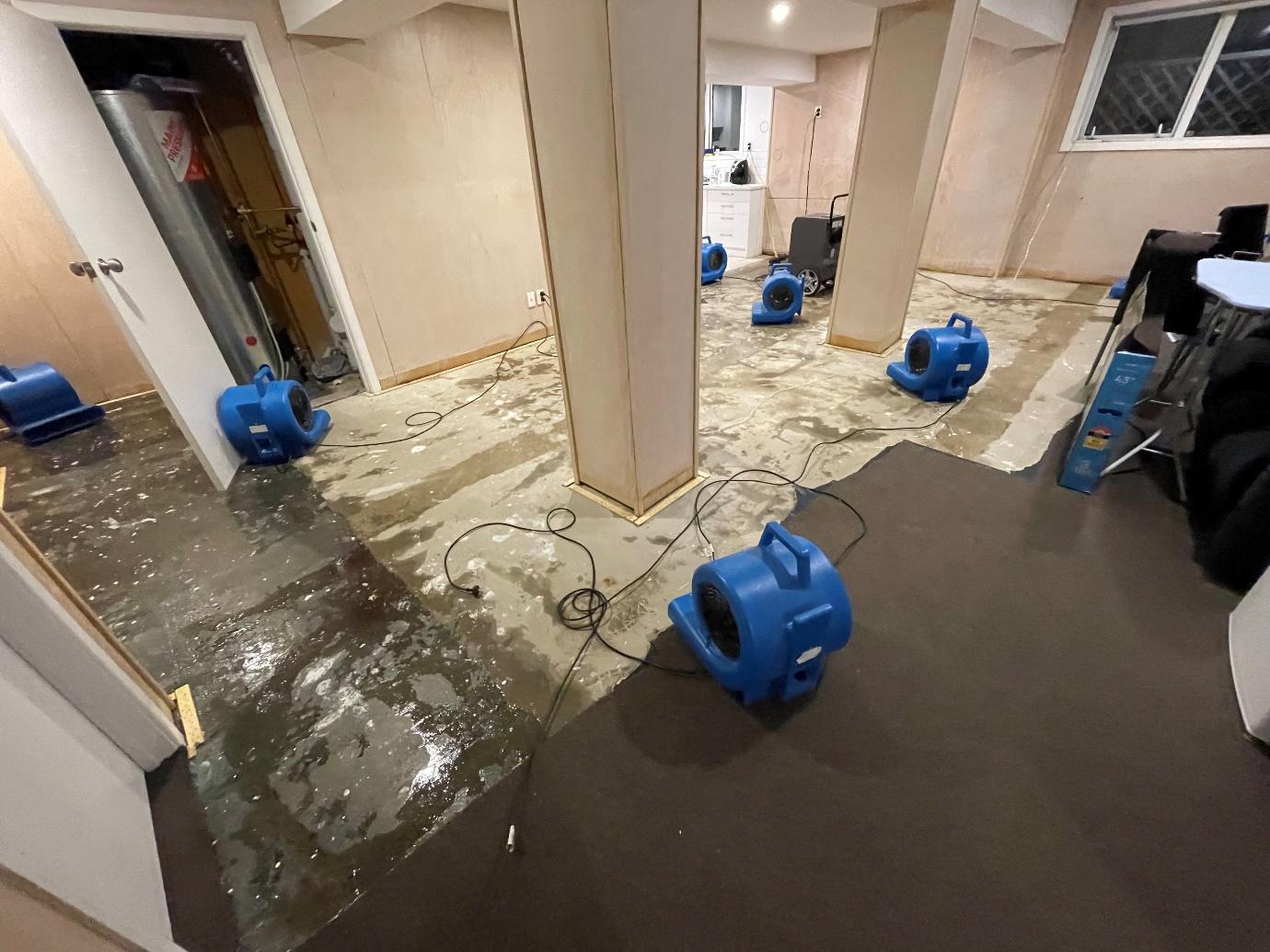 Commercial air movers positioned across the affected living area for structural drying